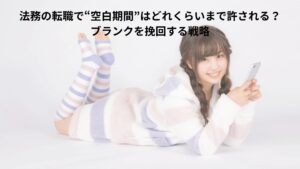 20代前半の日本人女性がスマートフォンを手に横になってる姿。